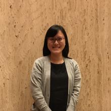 Elisa Sze on 16 November, smiling and wearing a black dress and grey cardigan. Photo by Anne Welsh.