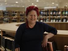 Renate Behrens smiling at the camera, in front of a marble wall.